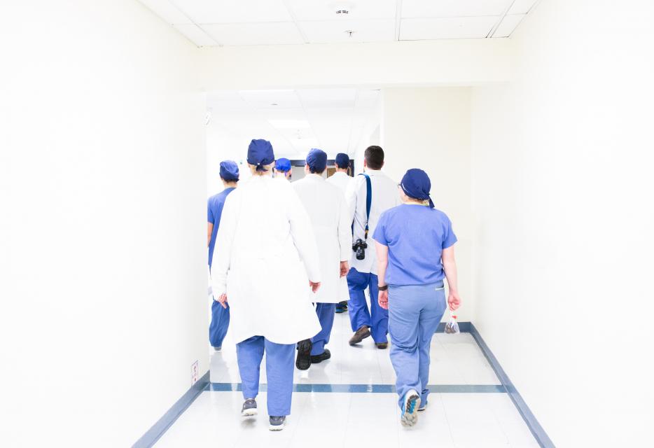 Medical students walking down a healthcare setting corridor, representing the medical school interview and applications process.