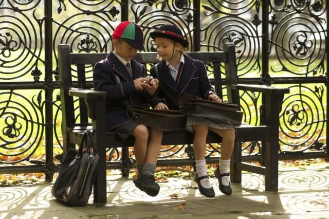 Two children sitting on an outdoor bench at their UK school, representing the work of William Clarence’s global and overseas education consultants.