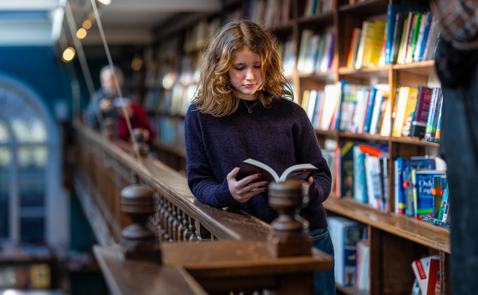 Student reading book in bookstore